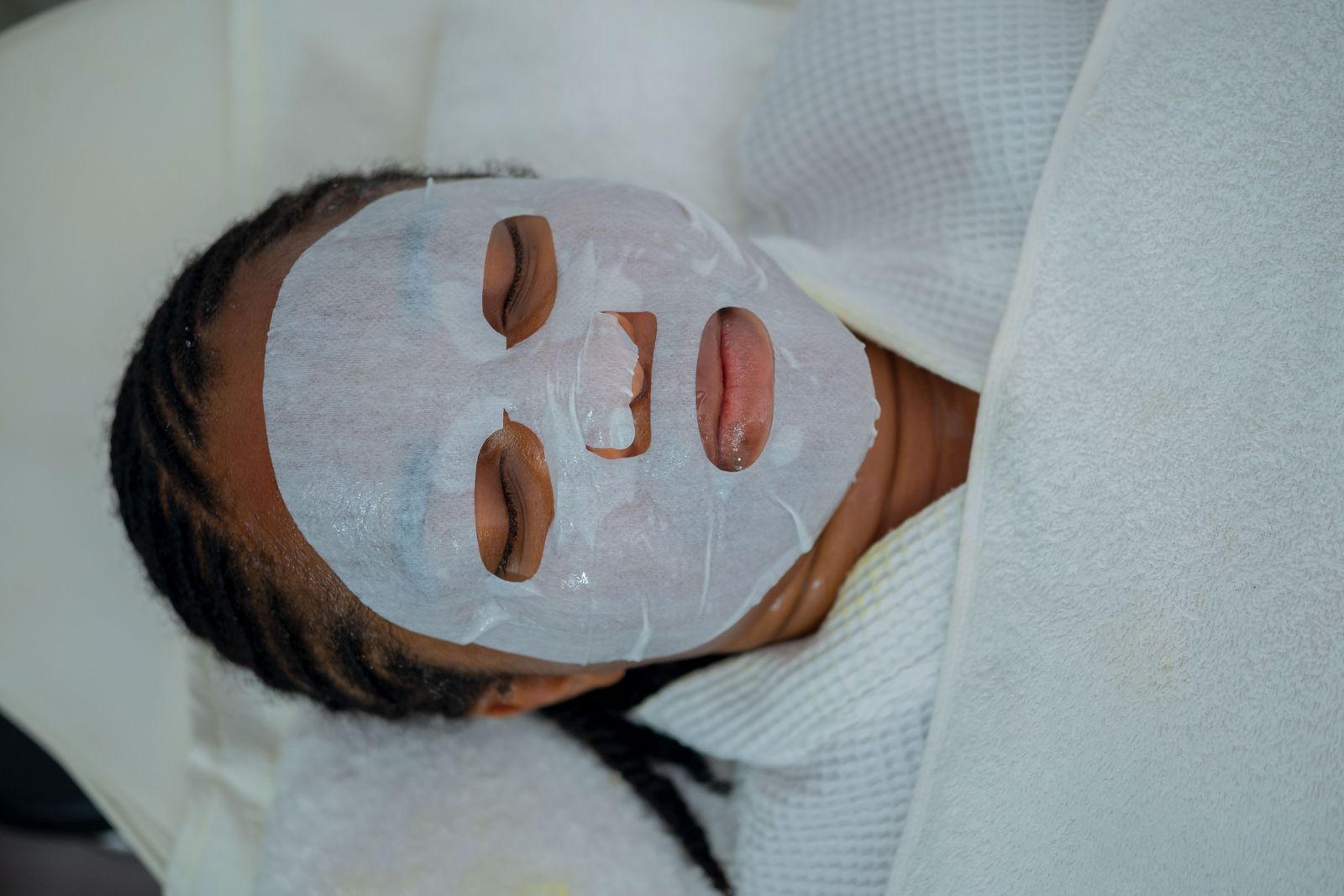 Woman resting with a facial mask at a spa in Nigeria